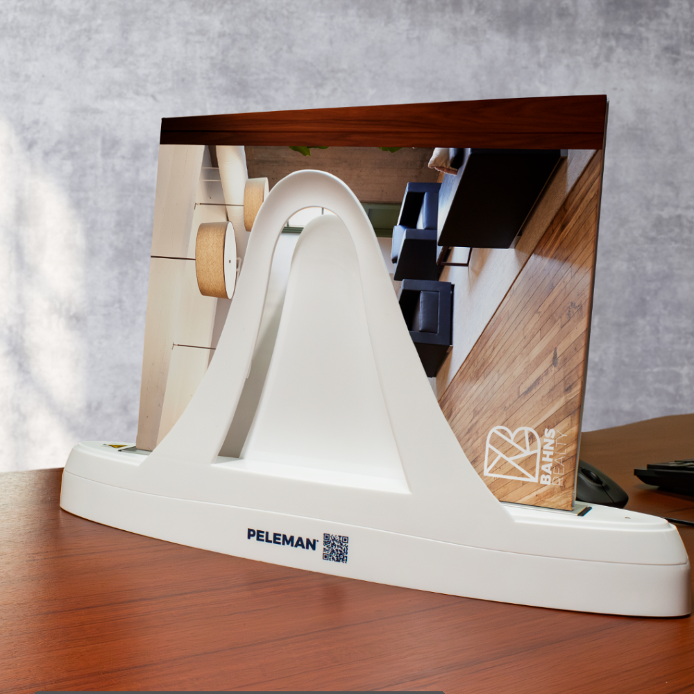 BHHS Cabernet Lay Flat Pocket Folder displayed in Peleman Thermal Binding Machine on wooden desk with Berkshire Hathaway HomeServices branding for professional real estate listing presentations